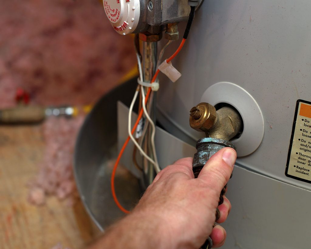 Hand Attaches Hose To Water Heater